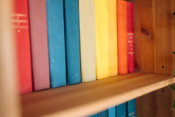 Many books on wooden shelf, close view