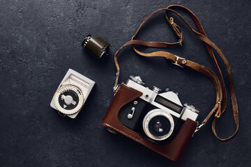 Old retro camera and vintage exposure meter on black background, flat lay