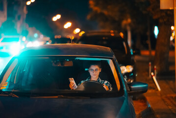 Lost female driver using mobile phone while driving at night.