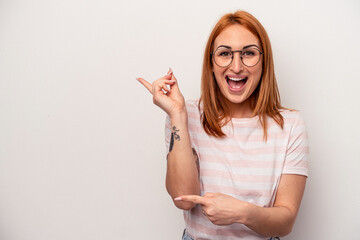 Young caucasian woman isolated on white background excited pointing with forefingers away.