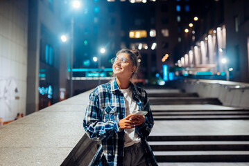 Woman with a smartphone in the night city © teksomolika