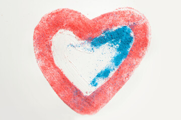 Obraz na płótnie Canvas The child draws with colored sand on heart-shaped paper. Valentine's Day theme. Fine motor skills, early education. Children's brain activity. Assignment idea for moms to work with a child at home.