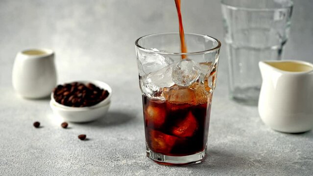 Pouring Cold Brewed Coffee over Ice. Making ice latte. Cold brew with ice and milk