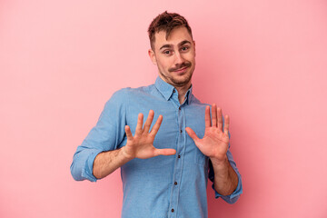 Young caucasian man isolated on pink background rejecting someone showing a gesture of disgust.