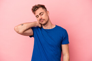 Young caucasian man isolated on pink background having a neck pain due to stress, massaging and touching it with hand.