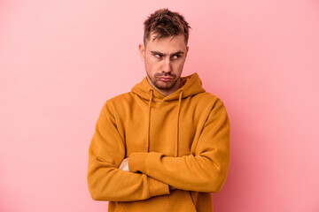 Fototapeta premium Young caucasian man isolated on pink background tired of a repetitive task.