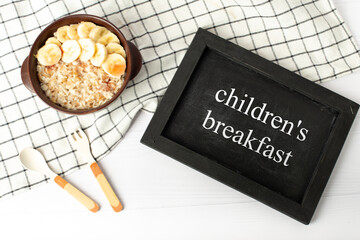 children's breakfast. oatmeal with bananas. breakfast on chalkboard for kids