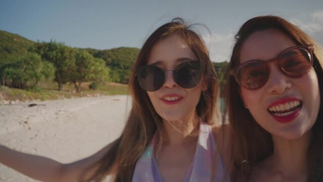 Two Asian young women having fun and enjoy vlogging from on the beach. Summer vacation at sea for a happy female...Young adult woman who is carefree and freedom. Lifestyle, blogger travel