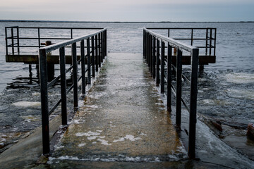 Frozen watching platform on the Mangalsala or Eastern pier in Riga, Latvia where the river Daugava flows into the Baltic Sea.