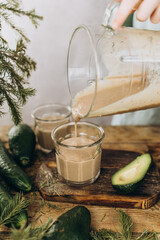 Freshly prepared smoothie is poured into a glass