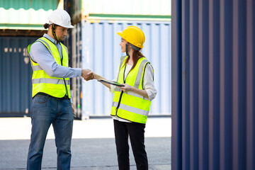 Caucasian Man manager and woman Supervisor dock cargo handshaking after good deal at container yard port of import and export goods. Unity and teamwork concept