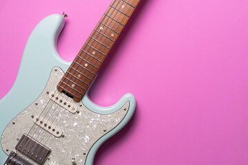 Electric guitar on pink table background, close up music concept