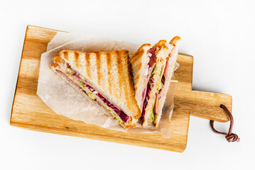 Sandwich with ham, cheese, tomatoes, lettuce, and toasted bread.