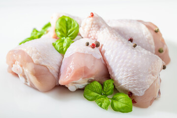Raw uncooked chicken drumsticks. Raw butchered chicken meat with fresh herbs ready for cooking.