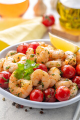 Fried shrimp with fresh vegetables. Shrimp salad with cherry tomatoes, garlic, fresh herbs and olive oil.