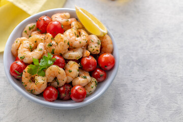 Fried shrimp with fresh vegetables. Shrimp salad with cherry tomatoes, garlic, fresh herbs and olive oil.