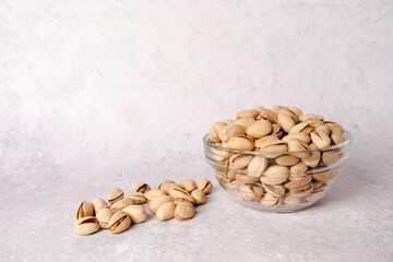 Pistachios nuts in plate on gray background, copy space