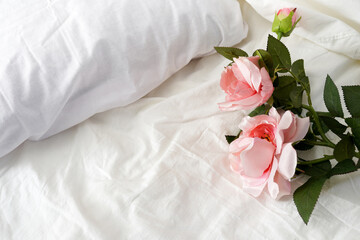 Bouquet of flowers roses on white textile bed. Still life banner with copy space