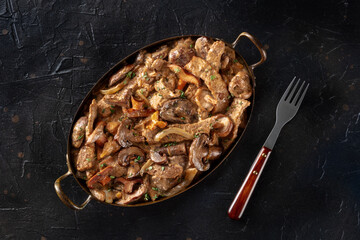 Beef stroganoff, mushroom and meat ragout with cream sauce, traditional Russian dish, in a skillet, top shot
