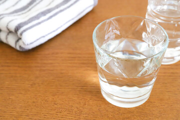 コップに入った水とペットボトルとタオル