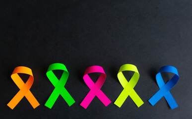 World cancer day background. Colorful ribbons, cancer awareness. On a black background