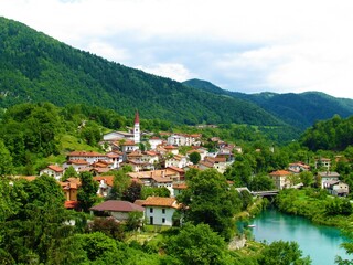 Fototapeta na wymiar Scenic village Most na Soci in littoral region of Slovenia surrounded by forest coverd hills and Soča riber in front in summer