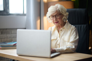 Woman typing on laptop sitting at table