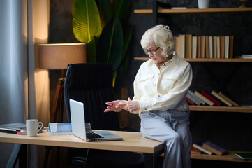 Woman looking at laptop counting on fingers