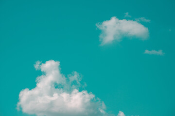 Photo of aqua blue sky with a group of white clouds in hard light contrast background. Abstract pop...