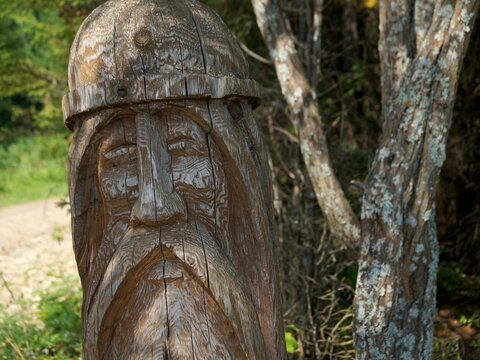 Slavic pagan idol in the forest. A wooden statue, an image of a Slavic god. An attribute of religious rites.