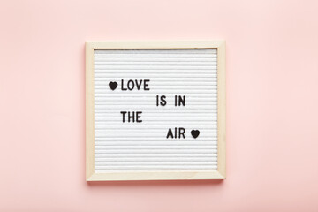 Letter board on pink background. Top view. Romantic background for Valentine's day