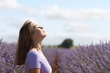 Woman relaxing in lavender field breathing fresh air