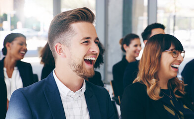 Obraz premium Light hearted moments keep everyone's attention. Shot of a group of businesspeople laughing while attending a conference.