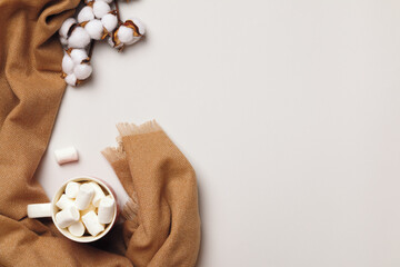 Beige cashmere scarf cup marshmallow branch of cotton on a gray background. The concept of comfort and coziness. Flat lay copy space top view.
