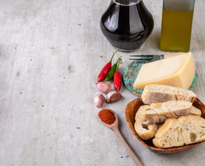 Bread, parmesan cheese, olive oil, chilli and garlic over wooden table. Mediterranean food with copy space