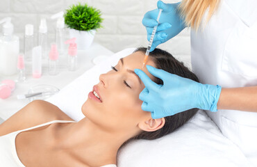 Obraz na płótnie Canvas Cosmetologist makes rejuvenating anti wrinkle injections on the face of a beautiful woman. Female aesthetic cosmetology in a beauty salon.