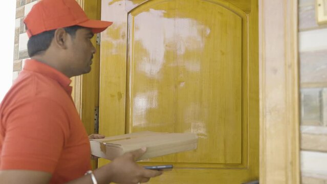 young indian customer paying delivery boy by scanning qr code on mobile phone at door step - concept of contectless or cashless payment,technology and shipment service.