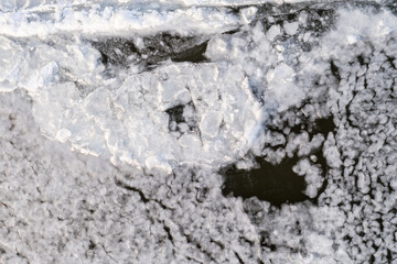 abstract texture of broken ice and dark water. background of the frozen surface of a clean lake or river