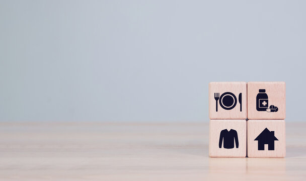 Wooden cube with food, Clothing, housing, medicine, four basic human needs concept.