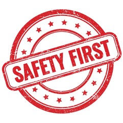 SAFETY FIRST text on red grungy round rubber stamp.