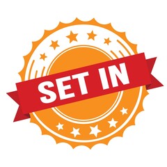 SET IN text on red orange ribbon stamp.