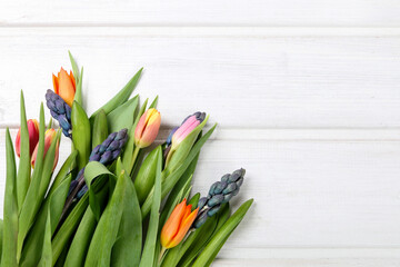 Colorful tulips and hyacinth flowers on wooden background.