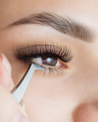 Extension of the lower eyelashes. a young woman undergoes a close-up eyelash extension procedure....