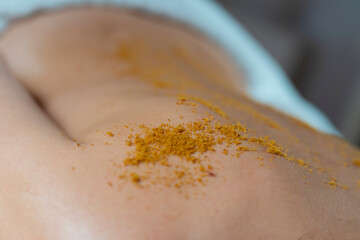 Exfoliating massage with brown sugar. Woman back and sugar detail