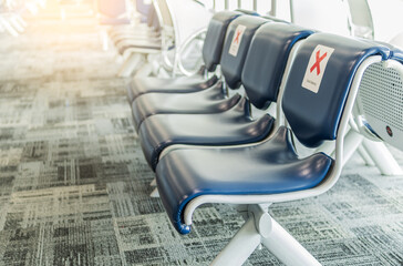 Empty chairs for distance in airport for passengers safety with coronavirus