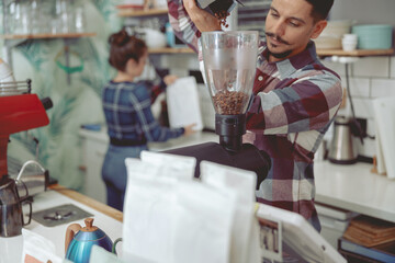 Man grinding coffee beans in electric grinder