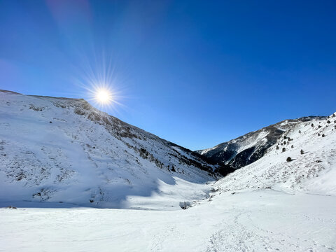 Picture of sun rising above the Nuria Valley mountains covered in snow at Catalan Pyrenees