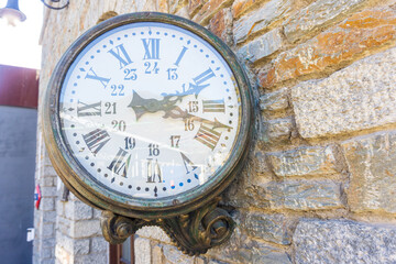 Fototapeta na wymiar Vintage train clock on the old facade of Ribes Vila train stop. Picture made from rack railway on its way to Nuria Valley Sanctuary.