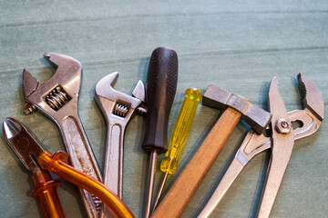 Screwdrivers, wrenches, pliers, hammer and spanner on a table. Assortment of different tools for the house