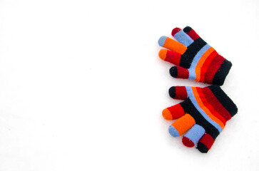a pair of children's knitted mittens lying on the snow
Gloves lie on a background of snow.